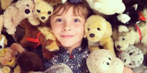 petite fille entourée de peluches
